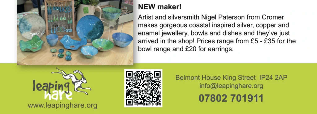 A colourful display of enamel jewellery and ceramic bowls in coastal tones of turquoise, blue and green arranged on a wooden table, with price tags visible. On the right is a description about artist Nigel Paterson’s work and contact info for Leaping Hare. A QR code and the shop’s contact details are also included on a bright green background.