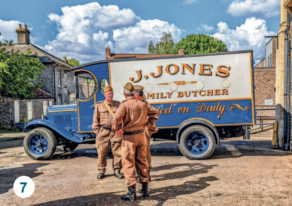 A vintage J. Jones Family Butcher delivery lorry, with three people in period military uniforms standing beside it during a historical re-enactment in Thetford.