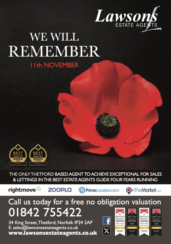 Remembrance-themed advertisement for Lawsons Estate Agents. A single red poppy lies against a black background with the words “We Will Remember – 11th November” in bold white and red text. The Lawsons logo appears in the top right corner. The lower section promotes the company’s awards and contact details, including their address on King Street, Thetford, phone number, website, and property awards logos.