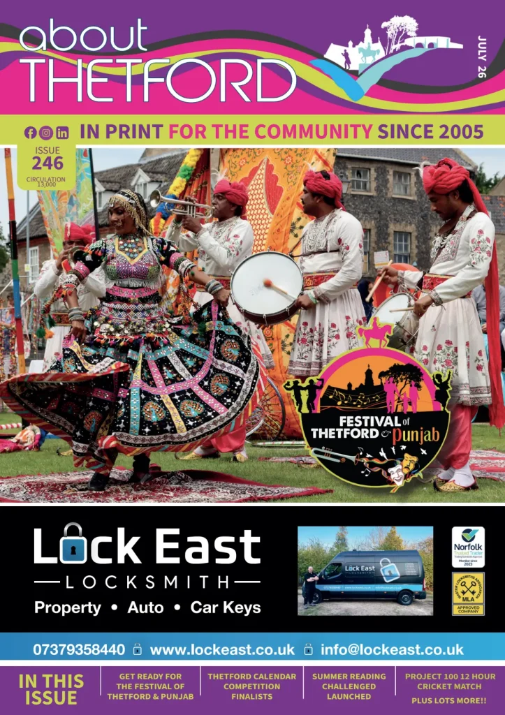 The July 2026 cover of About Thetford magazine. The main image shows performers in colourful traditional Punjabi dress dancing and playing drums and brass instruments during the Festival of Thetford & Punjab, with the festival logo overlaid in the bottom-right corner. A full-width advertisement for Lock East Locksmith appears beneath the cover image. The masthead includes the tagline "In Print for the Community Since 2005", Issue 246 and a circulation of 13,000. Along the bottom, teasers highlight stories including: "Get Ready for the Festival of Thetford & Punjab", "Thetford Calendar Competition Finalists", "Summer Reading Challenge Launched", "Project 100 12 Hour Cricket Match", and "Plus Lots More!!".